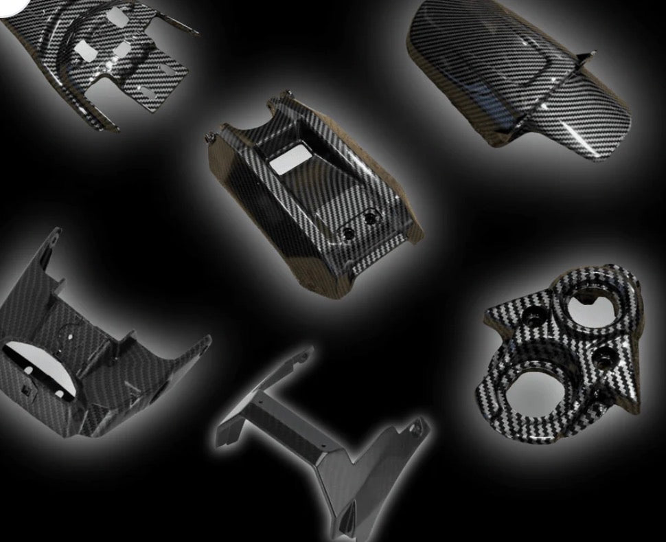 Carbon fiber styled kit for Surron LBX parts showcasing custom-molded components.