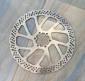 240MM motorcycle brake rotor for high-performance electric dirt bikes on a textured surface.