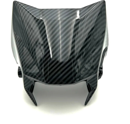 Surron Ultra Bee carbon fiber number plate housing front view, showcasing high-gloss carbon weave design.