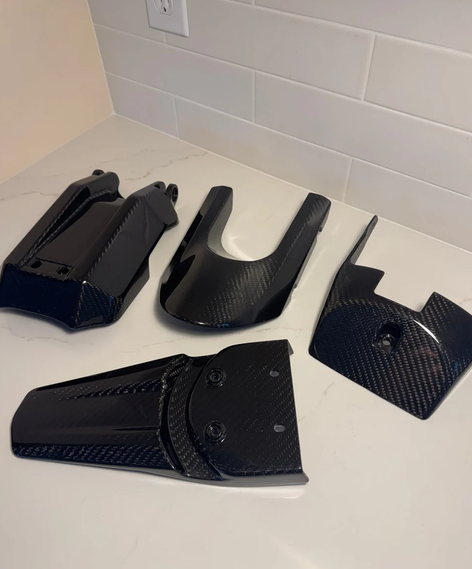 Set of components from the E Ride Pro REAL Carbon Fiber Kit for a carbon fiber e-scooter kit upgrade.