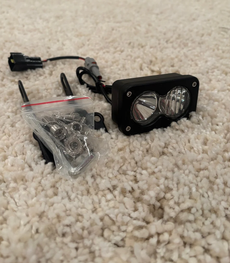 Talaria Baja light plug and play headlight kit with hardware on a carpeted surface.