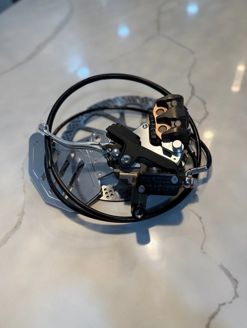 Surron Ultra Bee rear brake conversion kit featuring silver bracket, advanced heat dissipation, and durable brake components.
